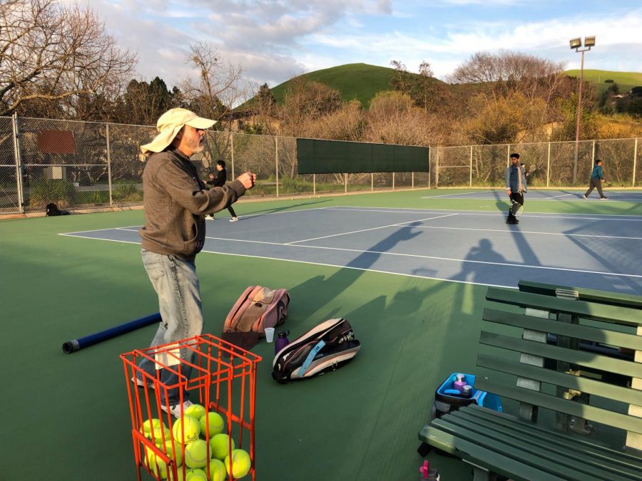 Coach Kurt on the courts for boys tennis team practice.