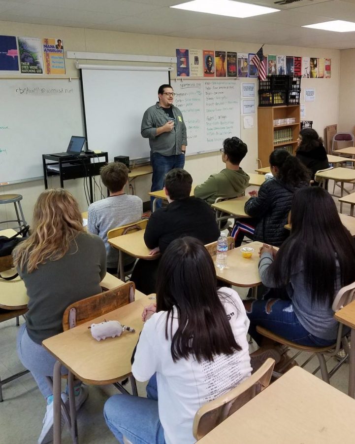 Students watch professional poet Brennan DeFrisco as he performs one of his original spoken word poems. 